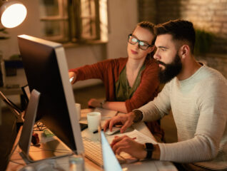 Young business colleagues using computer while working together in the office.