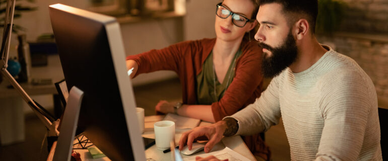 Young business colleagues using computer while working together in the office.